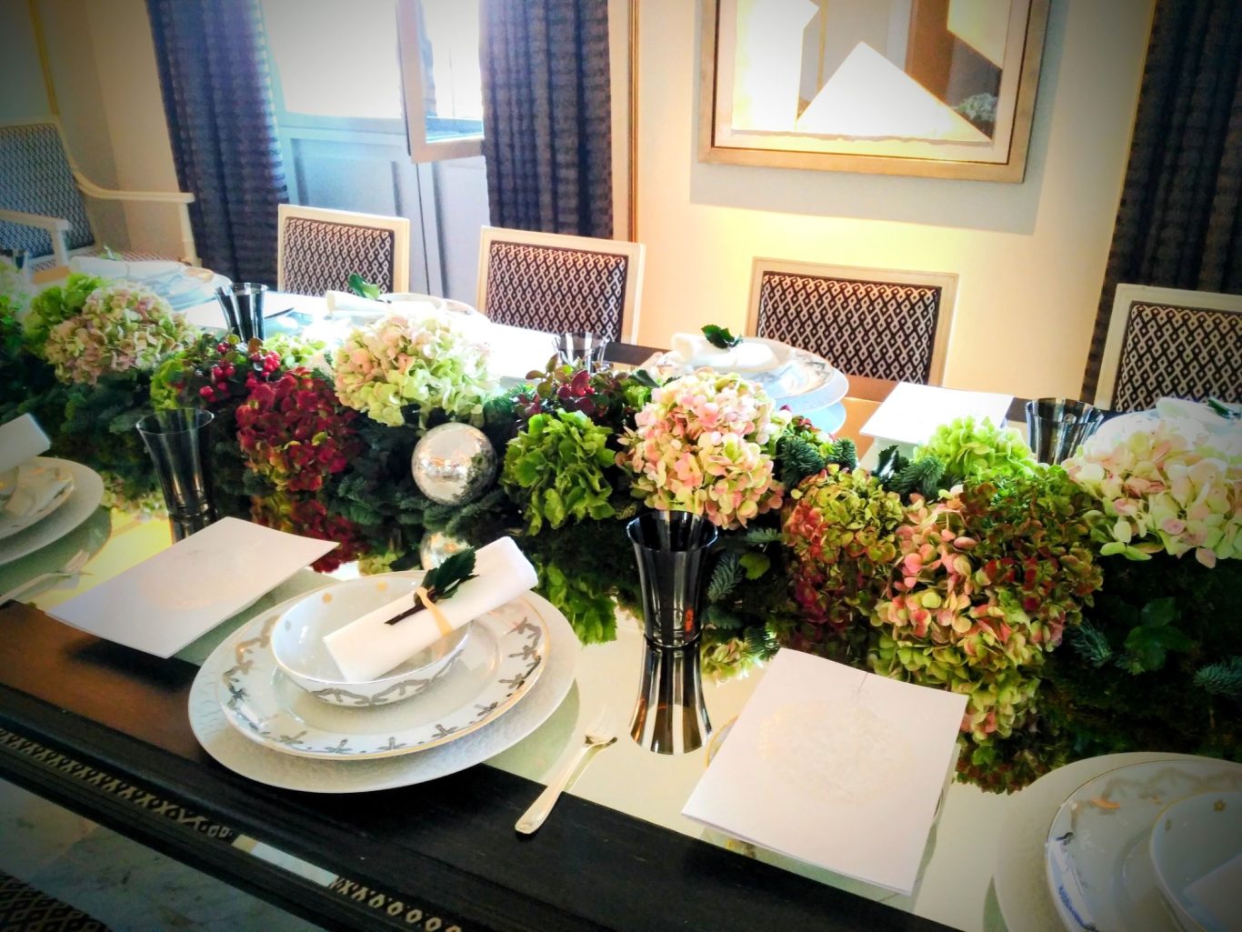 Mesa elegantemente decorada con centros de flores y vajilla dispuesta cuidando los detalles.